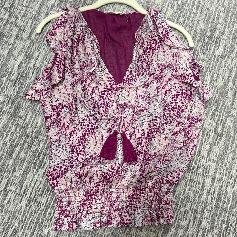 Silk top. Sleeveless with ruffled edges.